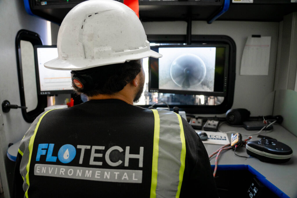 A technician operates a CCTV camera for pipe inspection, focusing on capturing detailed footage of the pipe's interior.