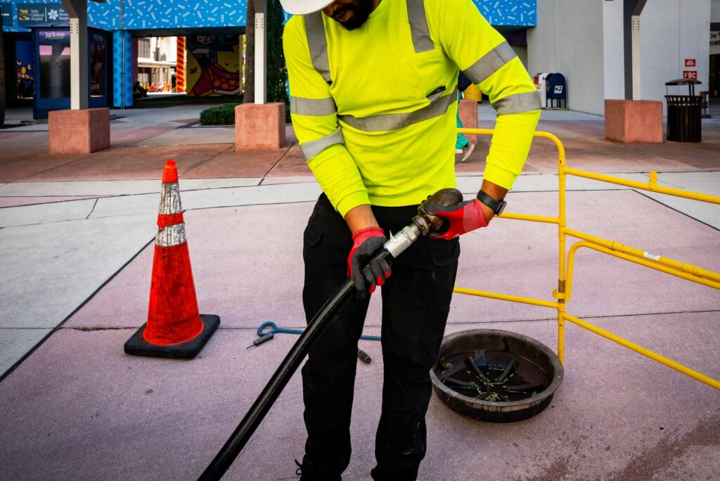A technician operates CCTV equipment to inspect underground pipes, capturing detailed footage for analysis.
